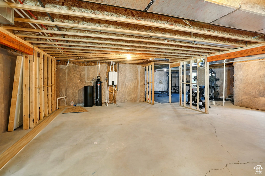 Unfinished basement with a water softener and water heater