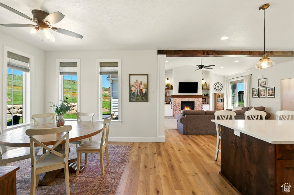 Dining space featuring ceiling fan, light wood-style floors, a brick fireplace, and recessed lighting