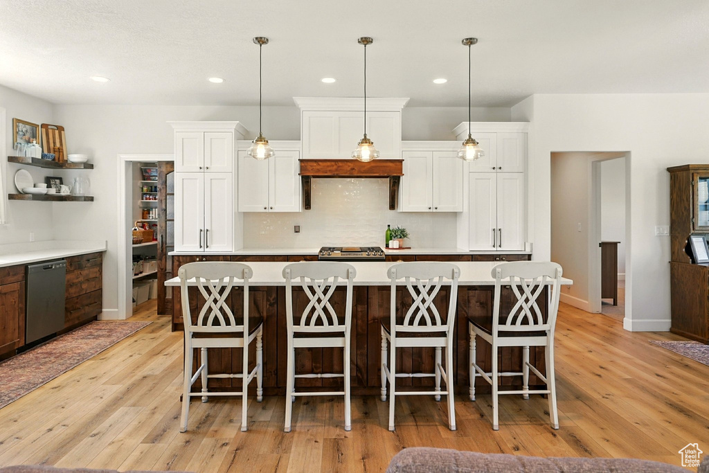 Kitchen featuring stainless steel dishwasher, open shelves, light wood-type flooring, white cabinetry, and recessed lighting