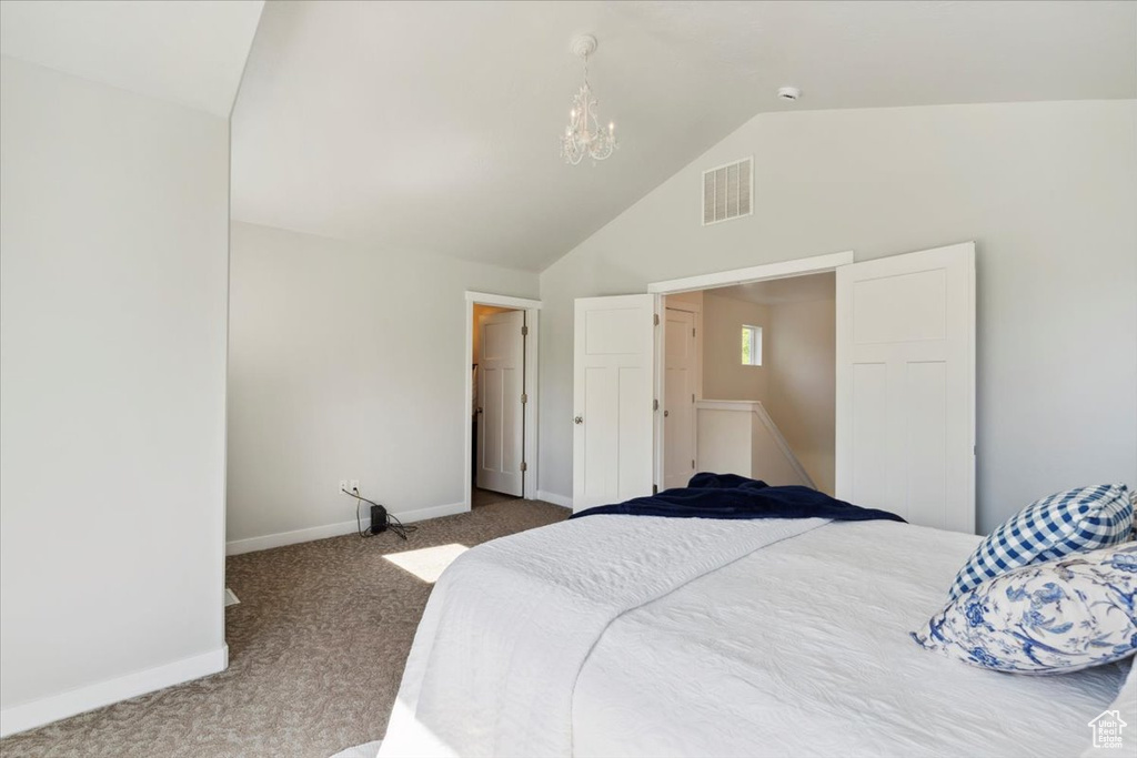 Bedroom featuring carpet flooring, vaulted ceiling, and a chandelier