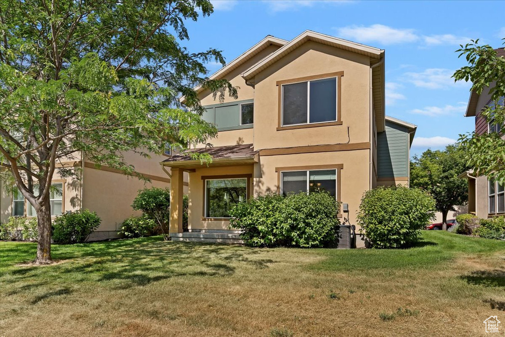 View of front of home with stucco siding and a front lawn