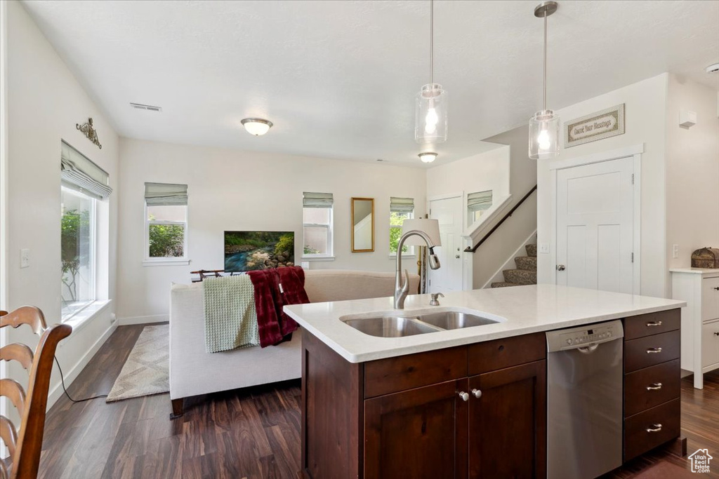 Kitchen with dishwasher, light countertops, dark wood-style floors, and open floor plan