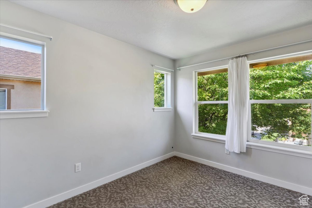 Carpeted empty room featuring baseboards