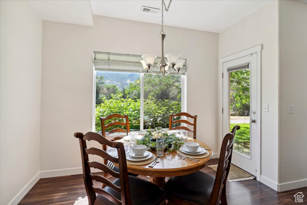 Dining room featuring a chandelier and dark wood-style flooring