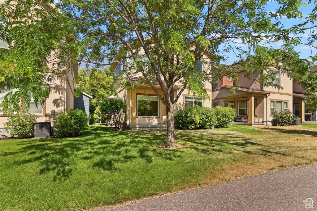 View of front of house featuring stucco siding and a front yard