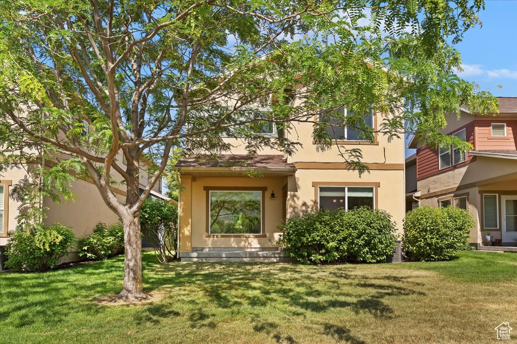 View of front facade featuring stucco siding and a front lawn
