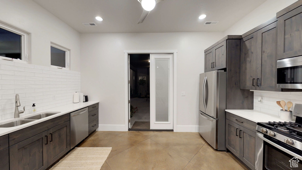 Kitchen with appliances with stainless steel finishes, backsplash, dark brown cabinetry, light countertops, and recessed lighting