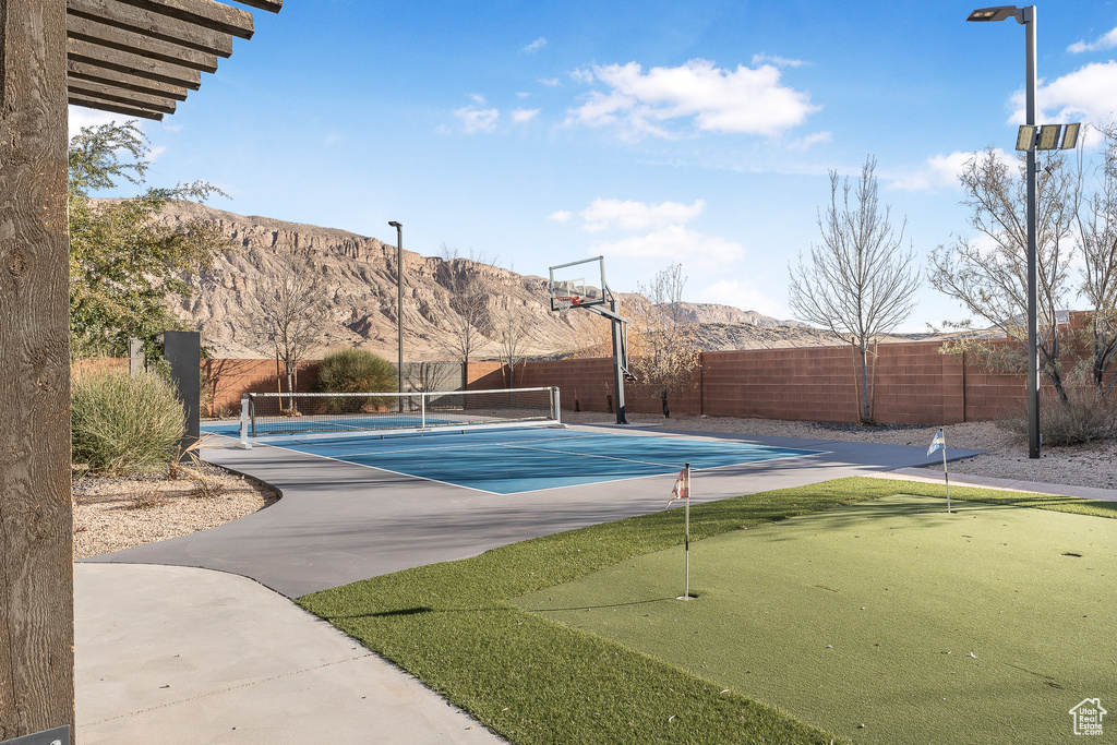View of tennis court with a putting area and a mountain view