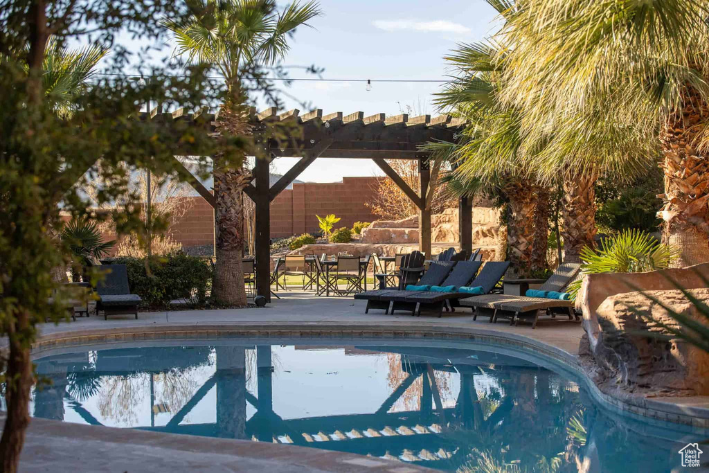 View of pool featuring a pergola, a patio area, and an outdoor hangout area