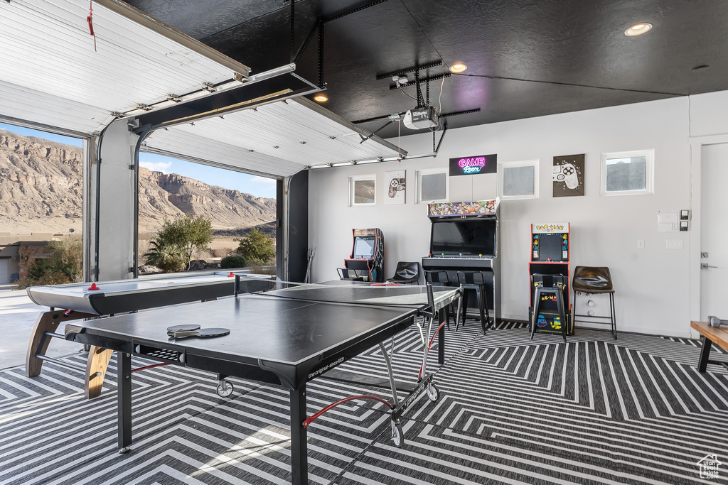 Recreation room featuring a mountain view, carpet, a garage, and recessed lighting