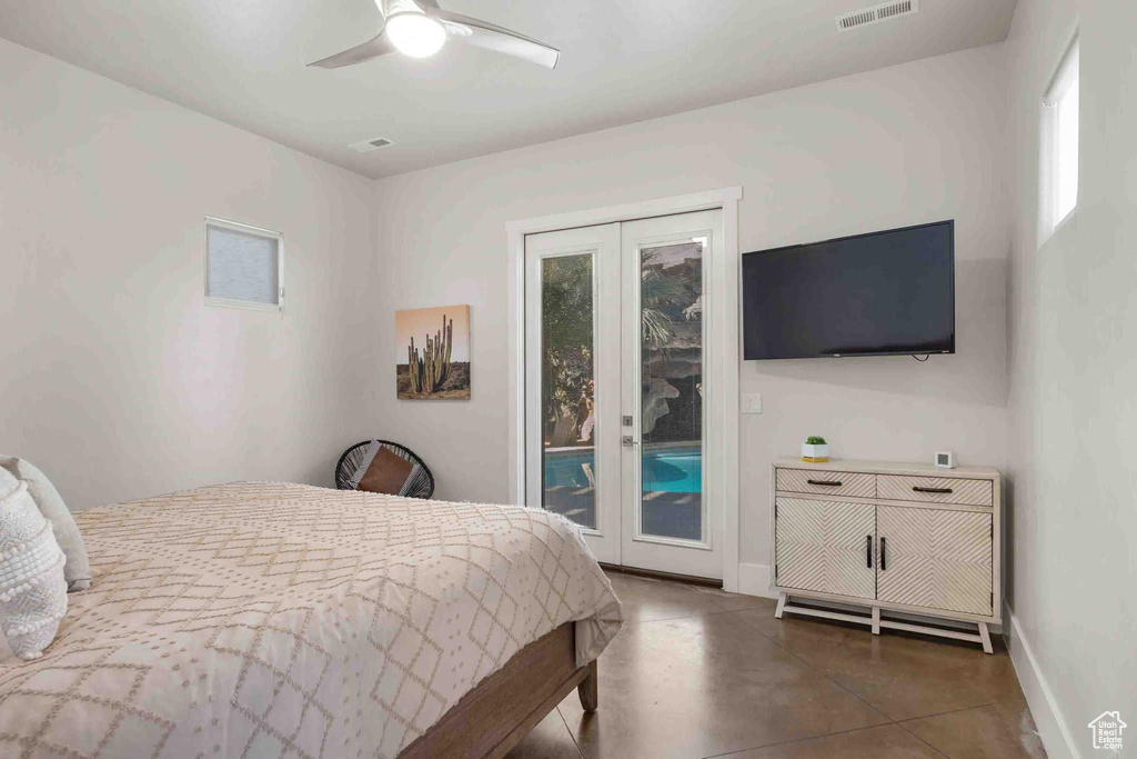 Bedroom with access to outside, finished concrete flooring, and ceiling fan