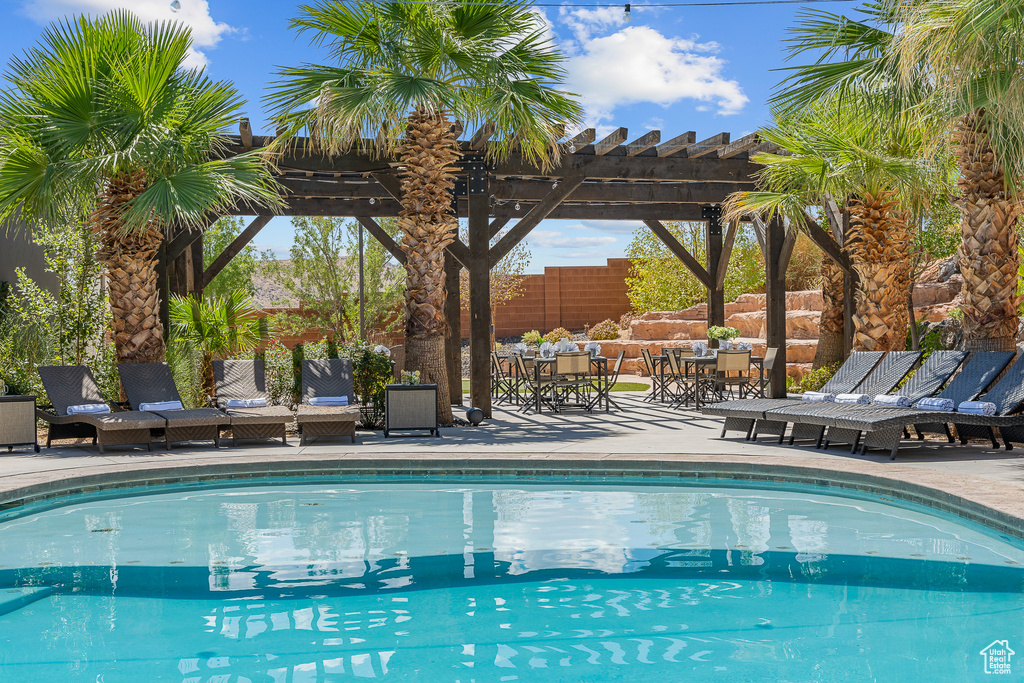 Swimming pool with a pergola, a patio, and outdoor dining space