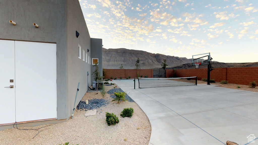 View of patio / terrace with a mountain view and a tennis court