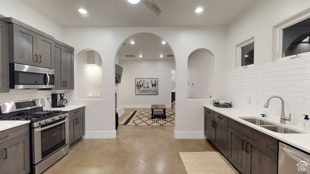 Kitchen featuring stainless steel appliances, tasteful backsplash, dark brown cabinets, light countertops, and recessed lighting