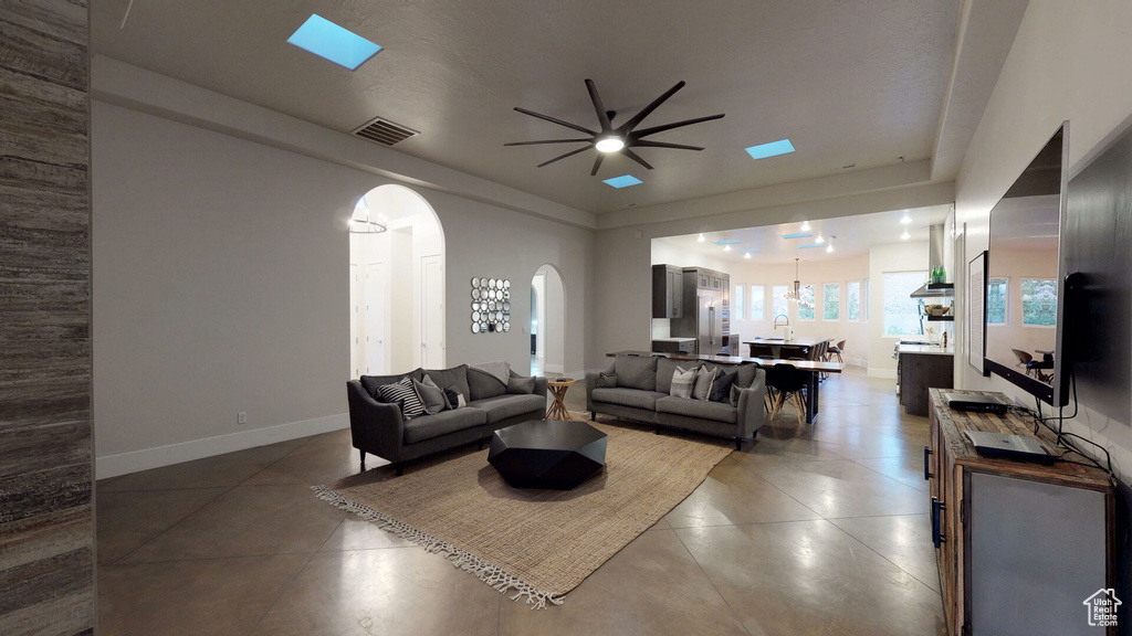 Tiled living area with arched walkways and ceiling fan