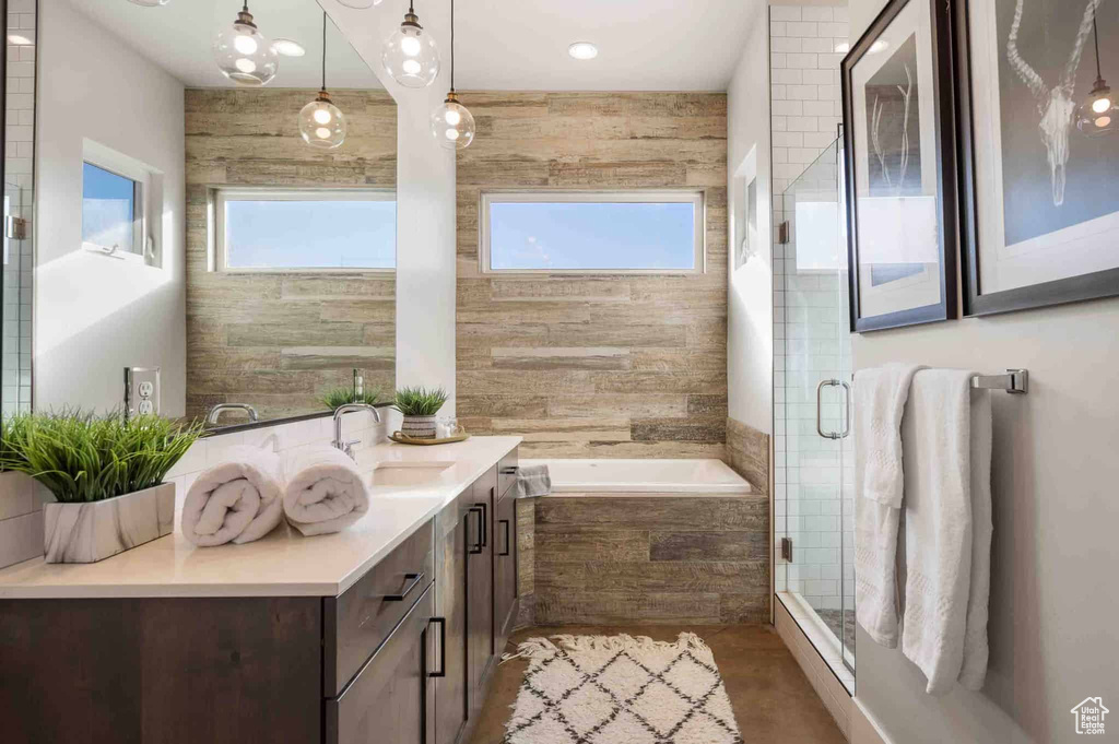 Full bathroom with plenty of natural light, vanity, a garden tub, and a stall shower