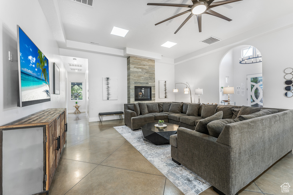 Living area with ceiling fan, arched walkways, and concrete floors