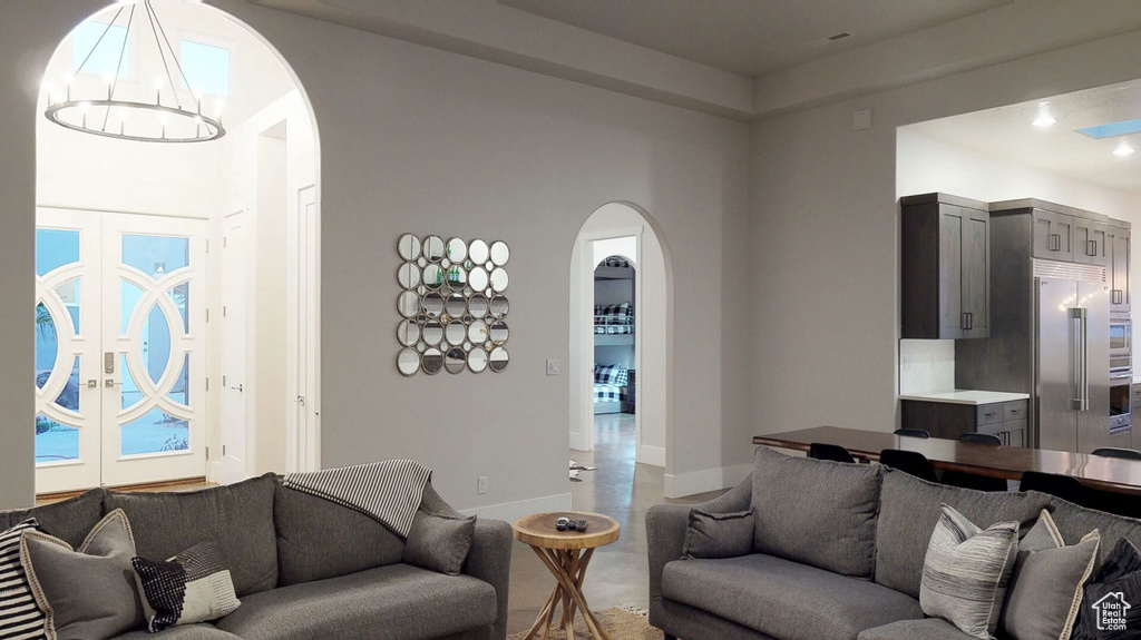 Living room featuring arched walkways, a chandelier, and recessed lighting
