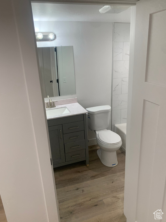 Full bath with vanity and wood finished floors