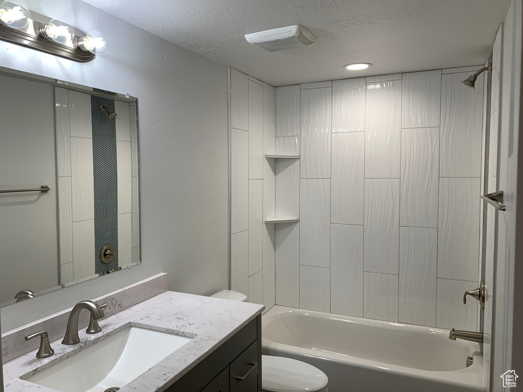 Full bathroom featuring vanity,  shower combination, and a textured ceiling