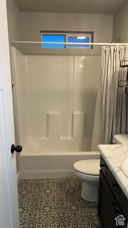 Bathroom with shower / bath combo with shower curtain, vanity, and tile patterned floors