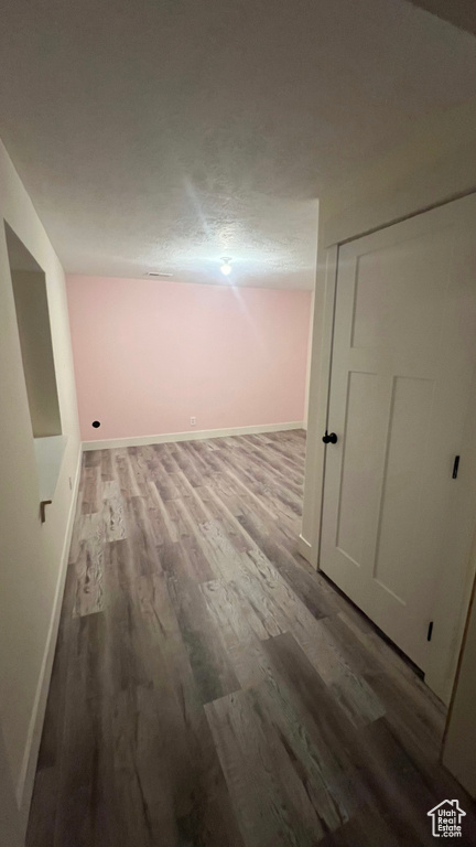 Hallway featuring wood finished floors and baseboards