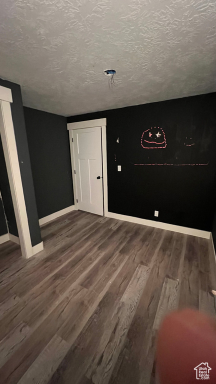 Unfurnished room with wood finished floors and a textured ceiling