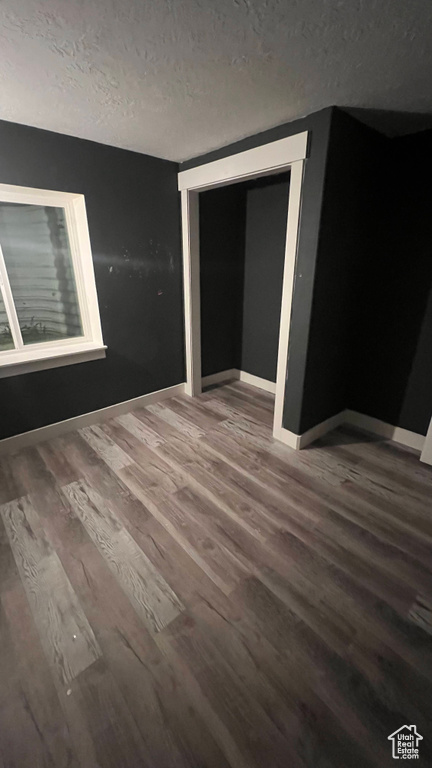 Unfurnished bedroom featuring wood finished floors and a textured ceiling
