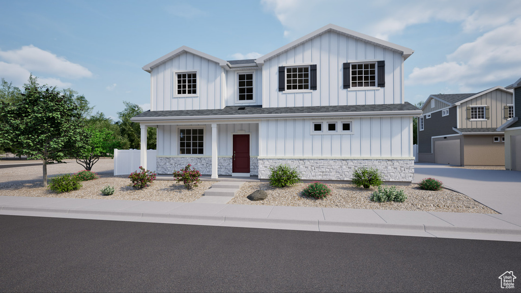 Modern farmhouse style home with board and batten siding, stone siding, a porch, and driveway