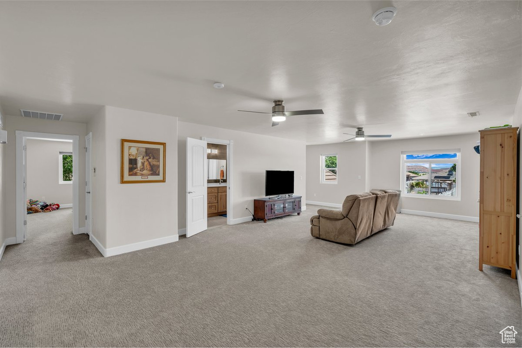 Carpeted living area featuring baseboards and a ceiling fan