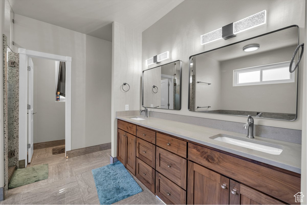 Full bathroom with double vanity and baseboards
