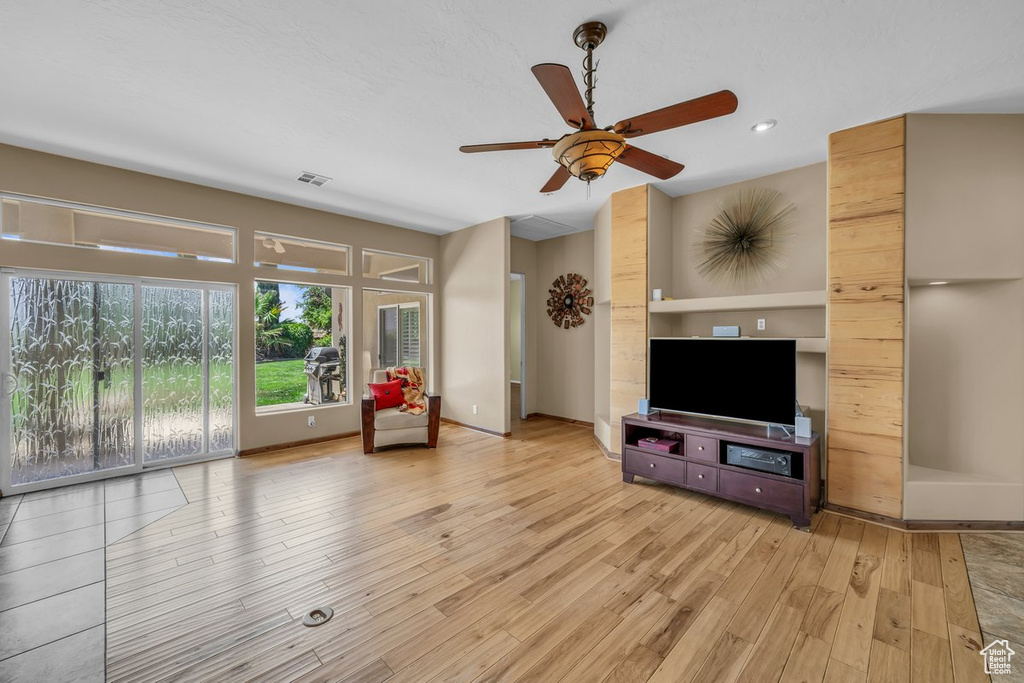 Living room featuring light wood-style flooring, a ceiling fan, and recessed lighting