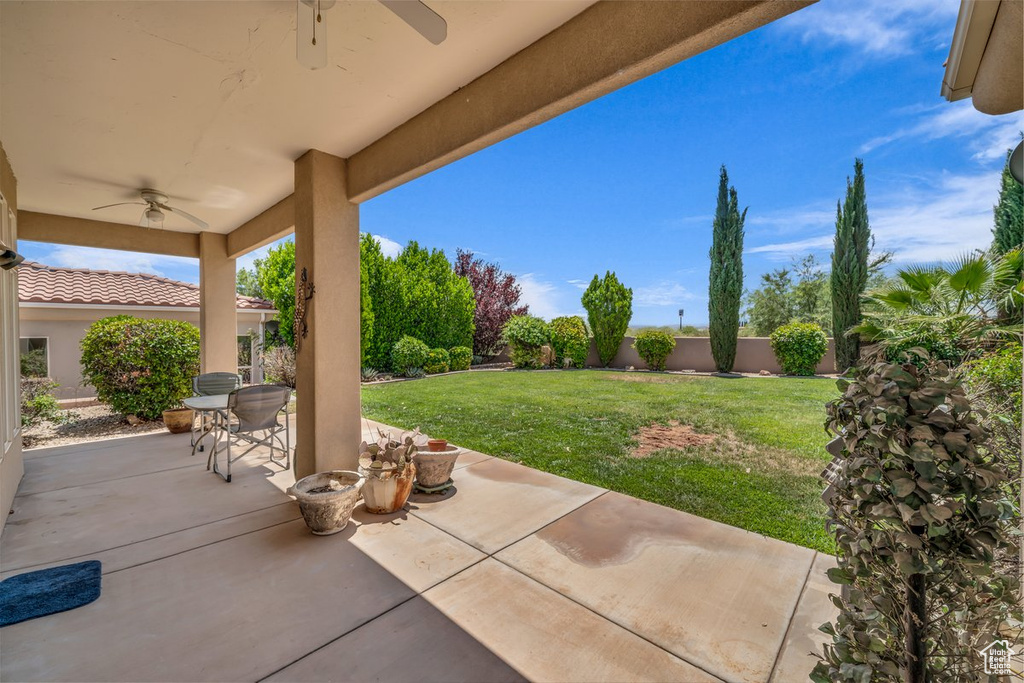Fenced backyard with a ceiling fan and a patio
