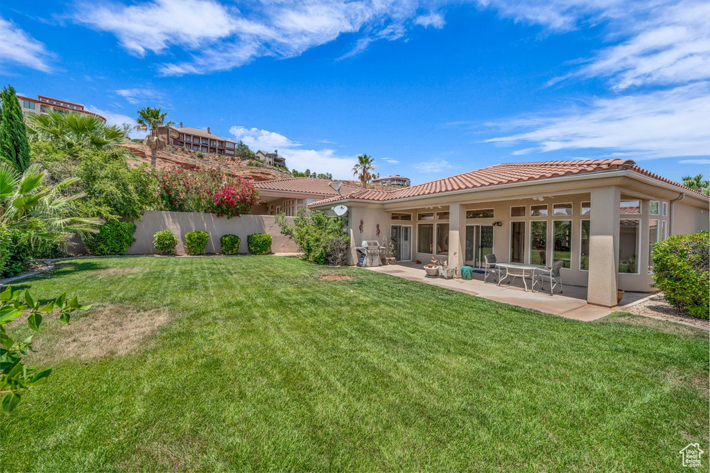 View of green lawn with a patio area