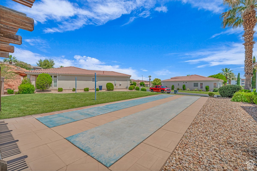 Surrounding community featuring shuffleboard and a yard