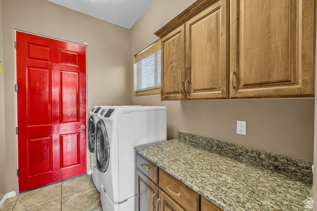 Laundry area featuring cabinet space, washing machine and clothes dryer, and light tile patterned floors