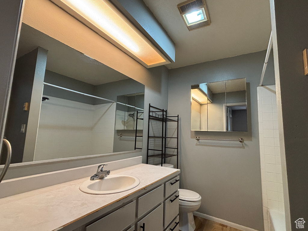Full bath with vanity and wood finished floors