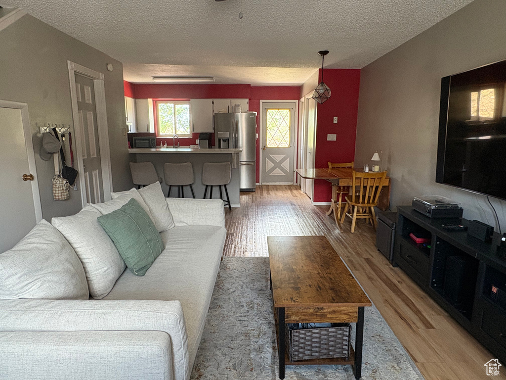 Living room with light wood-type flooring and a textured ceiling