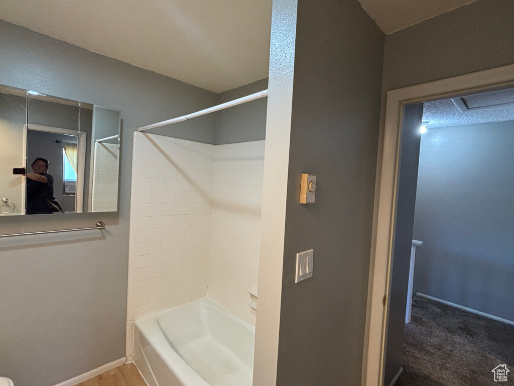 Bathroom with shower / washtub combination and baseboards