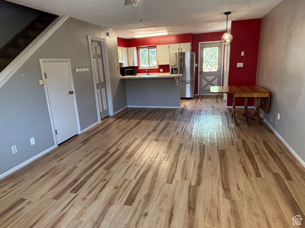 Unfurnished living room featuring wood finished floors and a textured ceiling