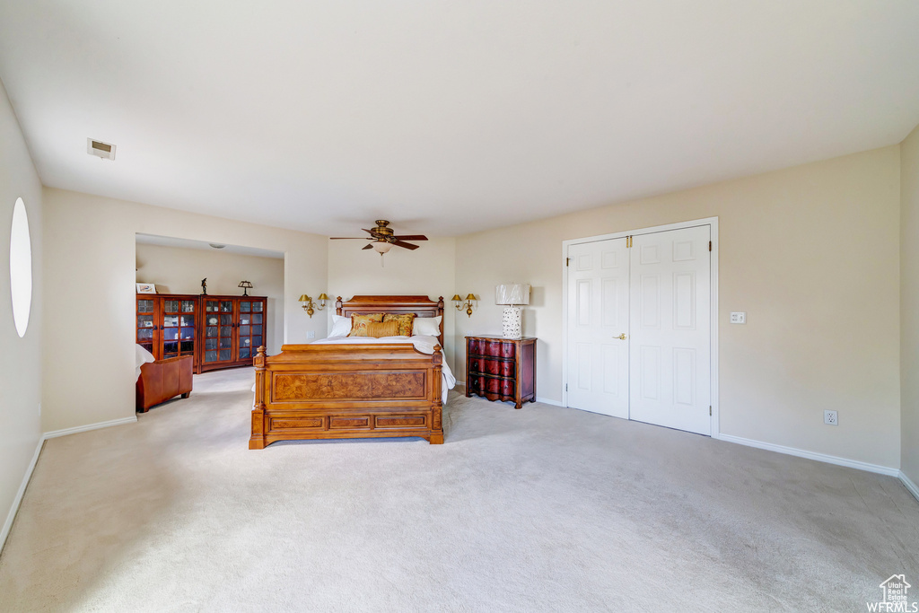 Bedroom with carpet floors, ceiling fan, and a closet