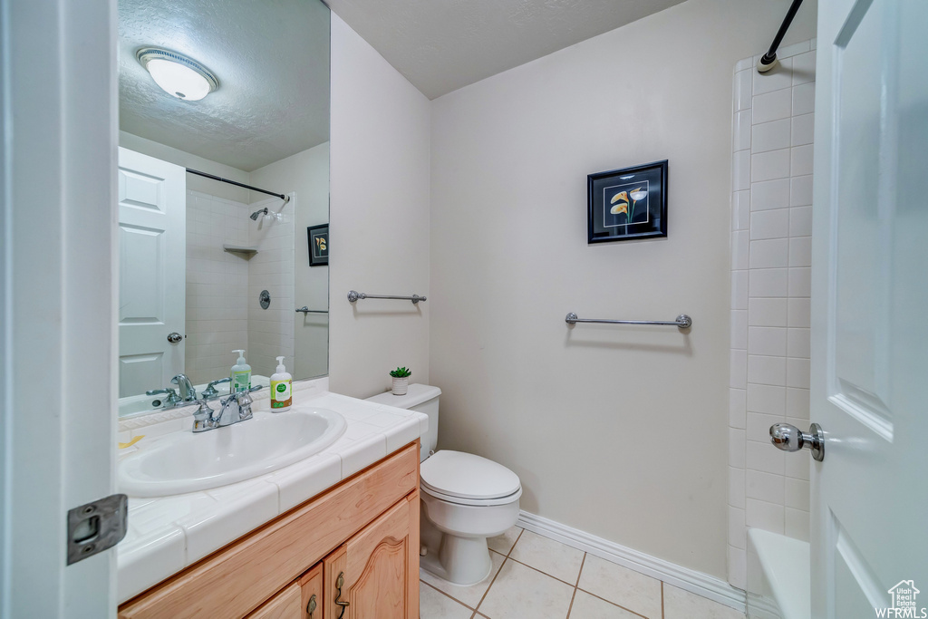 Bathroom with vanity, tile patterned floors, and shower / bathtub combination