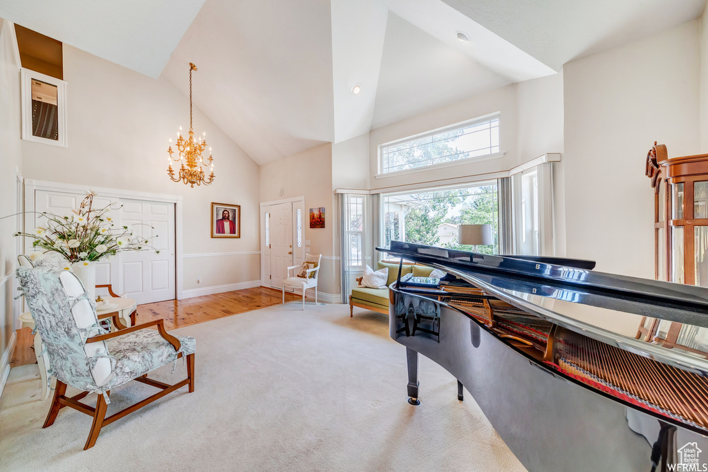 Interior space featuring high vaulted ceiling, a chandelier, and wood finished floors