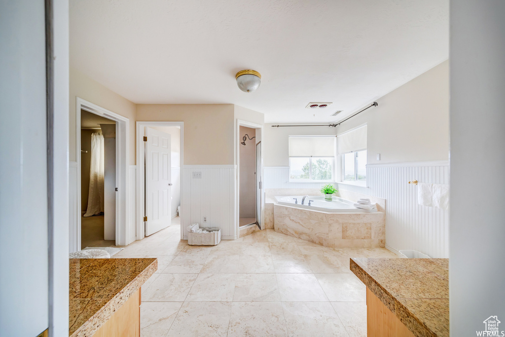 Bathroom featuring a garden tub and wainscoting