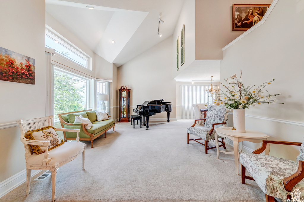 Living area featuring high vaulted ceiling, carpet floors, and a chandelier