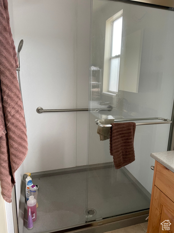 Bathroom featuring a stall shower, vanity, and tile patterned floors