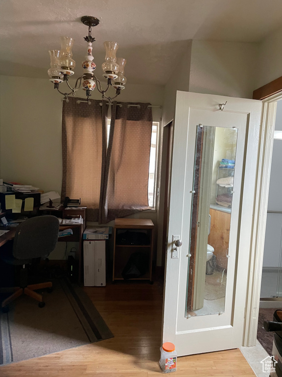 Office area featuring a chandelier and wood finished floors