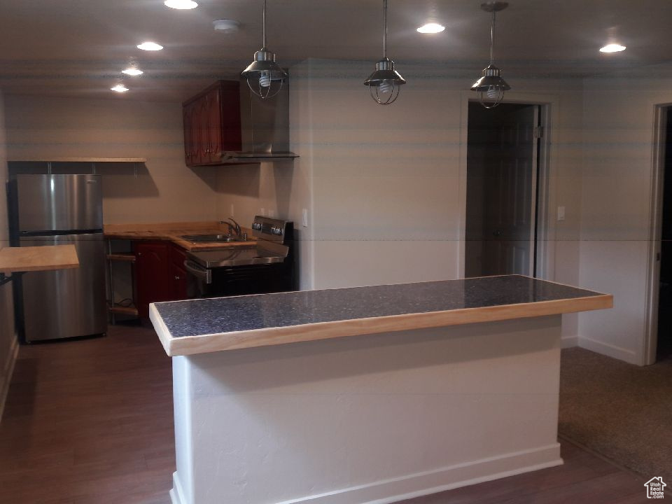 Kitchen featuring freestanding refrigerator, ventilation hood, electric range oven, recessed lighting, and dark wood-type flooring