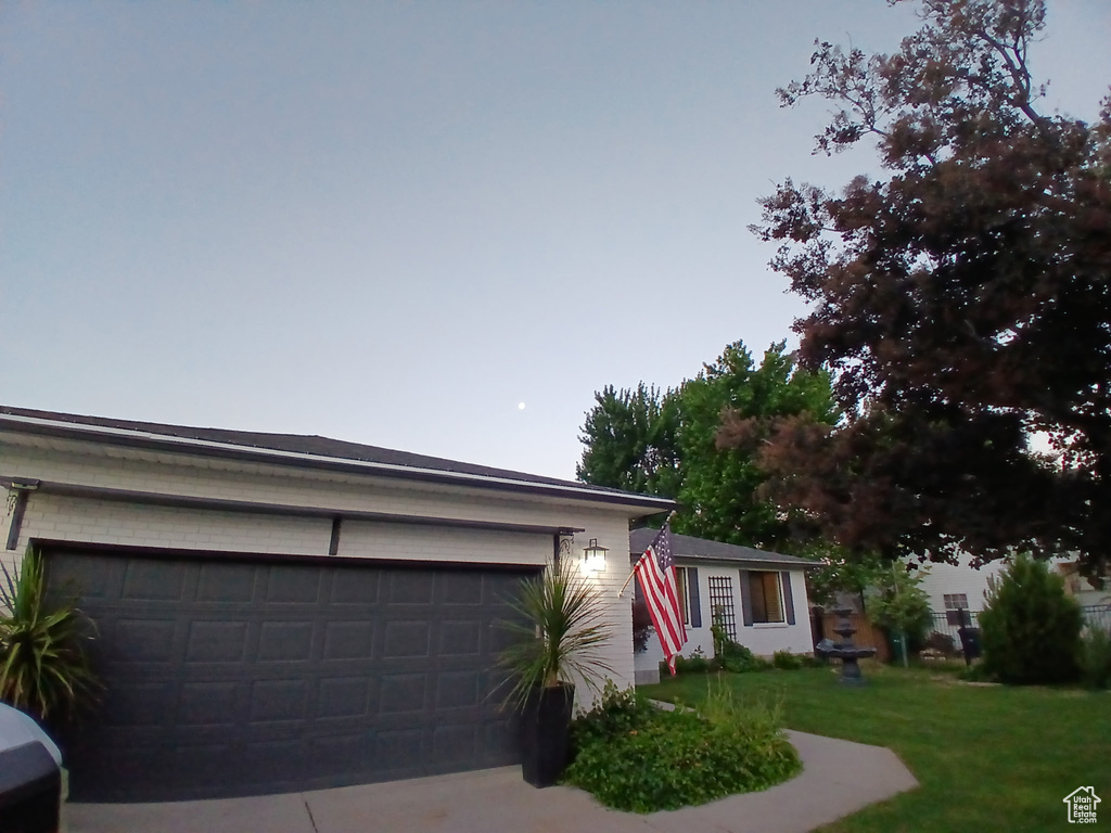 Single story home featuring a front yard, concrete driveway, and a garage