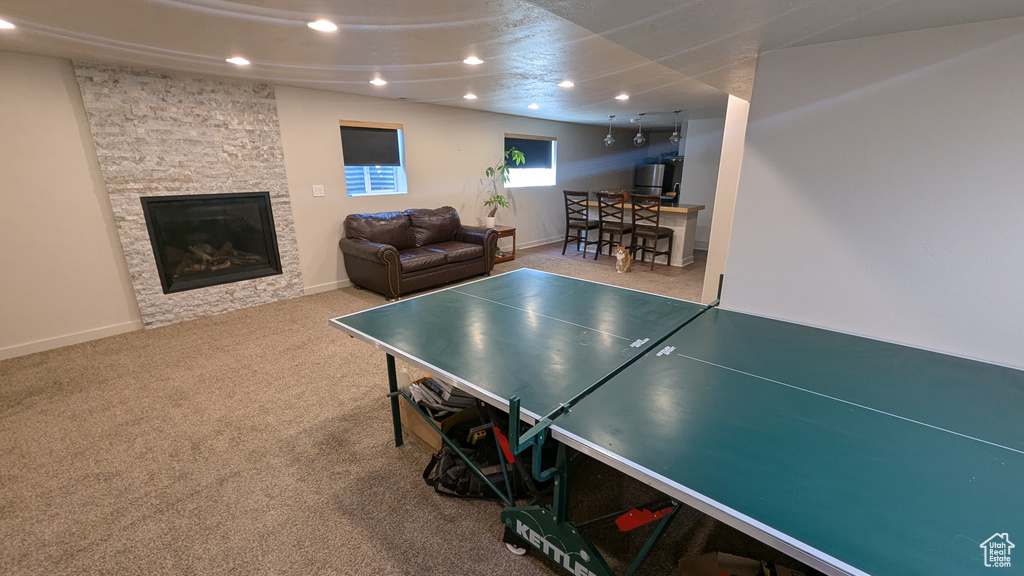 Rec room featuring recessed lighting, a stone fireplace, and carpet flooring